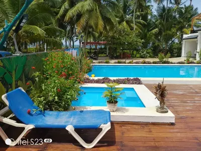 a blue chair sitting next to a swimming pool at Villa Dario in Nagua