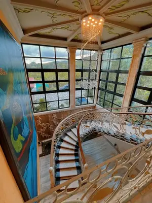a spiral staircase in a room with windows at Villa Tesoros del Mar - Luxury Beachfront Villa with Natural Pool, Jacuzzi, Mountain Views, Yoga, BBQ, Wi-Fi, Pet & Family Friendly, Barahona Adventures in El Arroyo