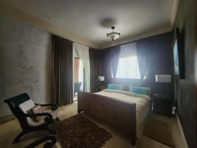 a bedroom with a bed and a chair and a window at Villa Tesoros del Mar - Luxury Beachfront Villa with Natural Pool, Jacuzzi, Mountain Views, Yoga, BBQ, Wi-Fi, Pet & Family Friendly, Barahona Adventures in El Arroyo