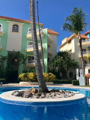 a resort with a palm tree and a swimming pool at Palm Suites E-6-two-level apartment with a view of the pool in Punta Cana