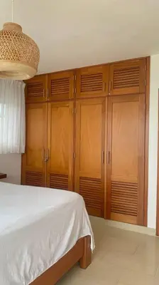 a bedroom with wooden cabinets and a white bed at B3 beautiful ocean view penthouse - Ocean Front in Cabarete
