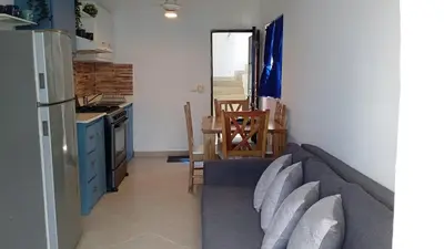 a living room with a couch and a kitchen at apart Jacaranda Bayahibe in Bayahibe