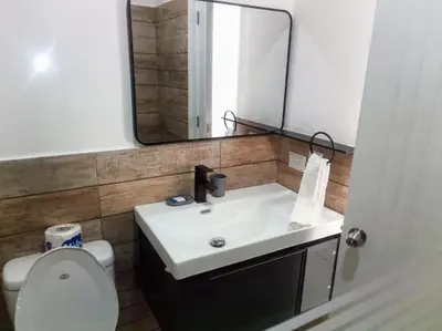 a bathroom with a toilet and a sink and a mirror at Ocean Bliss in Sosúa