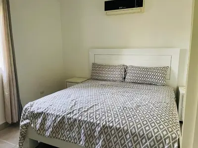 a bedroom with a bed with a white bedspread at Luxurious Villa in Sosúa + Pool in Sosúa