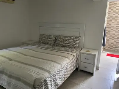 a small bedroom with a bed and a night stand at Luxurious Villa in Sosúa + Pool in Sosúa