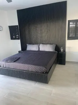 a bed in a bedroom with a black headboard at Level suites VIP in Sosúa