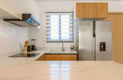 a kitchen with a refrigerator and a sink at Beautiful apartment with direct access to the pool in Punta Cana