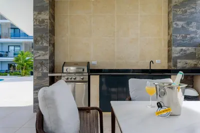 a kitchen with a table with a glass of wine at Beautiful apartment with direct access to the pool in Punta Cana