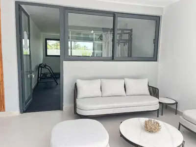 a living room with a couch and two tables at Beautiful apartment with direct access to the pool in Punta Cana