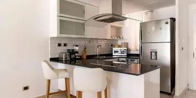 a kitchen with a black counter and white appliances at Cana Rock Condos in Punta Cana