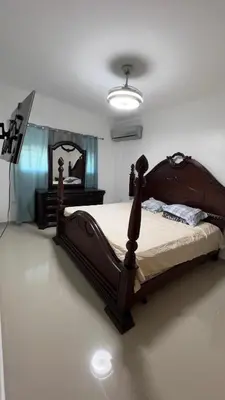 a bedroom with a wooden bed and a mirror at Apartamento completo con jacuzzi y gazebo in Santo Domingo