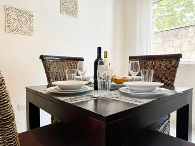 a dining room table with glasses and a bottle of wine at Tropical apartment 2 Bedroon in Los Corales in Punta Cana