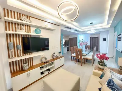 a living room with a television and a dining room at Luxury Gateaway Penthouse in front of Hard Rock in Punta Cana
