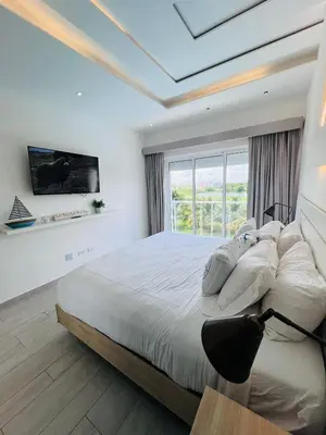 a bedroom with a large bed and a large window at Luxury Gateaway Penthouse in front of Hard Rock in Punta Cana