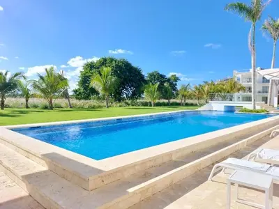 a swimming pool in a resort with palm trees at Luxury Gateaway Penthouse in front of Hard Rock in Punta Cana