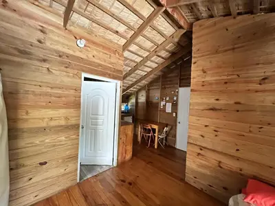 a room with wooden walls and a white door at Mango House Detox studio in Cabarete