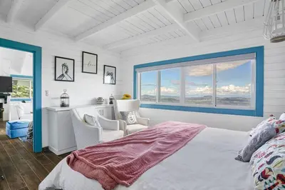 a bedroom with a bed and two chairs and a window at New-CasitaDeLasFlores-View-Wifi-Jacuzzi-Jarabacoa in Jarabacoa