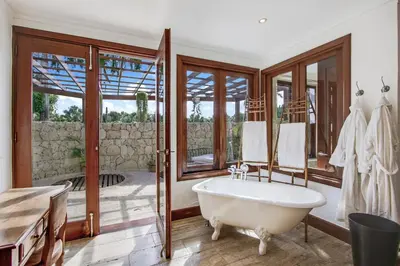 a bathroom with a tub and a large window at Gorgeous villa at Casa de Campo - with large pool, cook, maid and 2 golf carts in La Romana