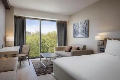 a hotel room with a bed and a living room at AC Hotel by Marriott Santiago de los Caballeros in Santiago de los Caballeros