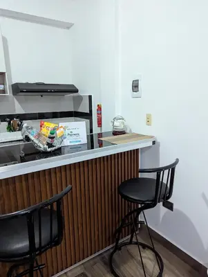 a bar with two black stools at a counter at A 7 minutos del Aeropuerto SDQ, Moderno y Compacto Apartamento in Boca Chica
