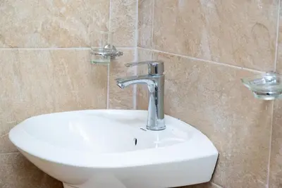a bathroom sink with a faucet in a bathroom at Apartahotel Señorial in Higuey