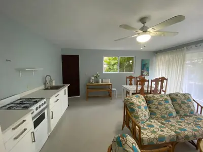 a kitchen and living room with a couch and a table at 2 BR & 1WR Suite at Villa Costa Verde near Playa Cofresi, Puerto Plata with a pool, balcony, and a rooftop terrace in San Felipe de Puerto Plata