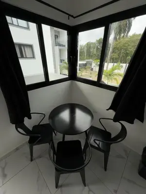 a table and chairs in a room with windows at LEVEL suites #7 in Sosúa