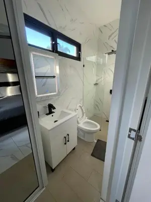 a white bathroom with a sink and a toilet at LEVEL suites #7 in Sosúa