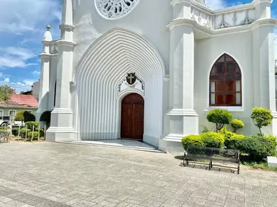 a church with a wooden door and a bench in front at Beautiful and peaceful 2-bedroom family condo in Juan Dolio