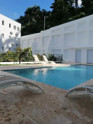 a swimming pool with chairs and a building at Sabrina Plaza Residence in Las Terrenas