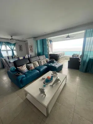 a living room with a blue couch and a table at Beachfront Apartment with Jacuzzi in Juan Pedro