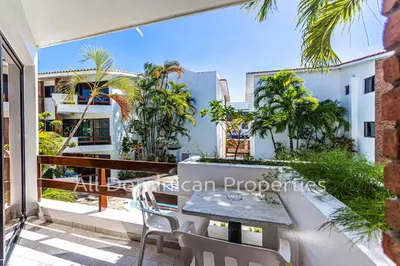 a balcony with a table and chairs and palm trees at Club Residential, Sosua in Sosúa