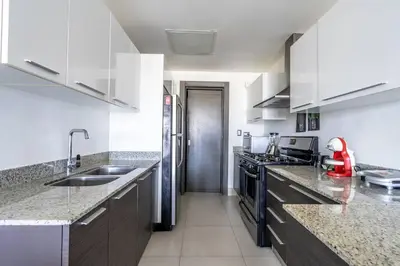 a kitchen with white cabinets and a counter top at Dream Rooftop Downtown View in Santo Domingo