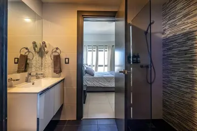 a bathroom with a sink and a shower with a bed at Dream Rooftop Downtown View in Santo Domingo