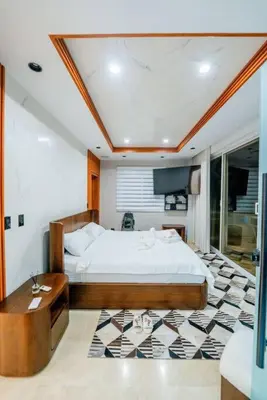 a bedroom with a bed and a table in it at Villa Hermosa en Metro Country Club Juan Dolio in Juan Dolio