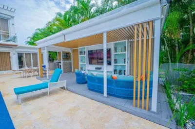 a house with a patio with blue furniture at Villa Hermosa en Metro Country Club Juan Dolio in Juan Dolio