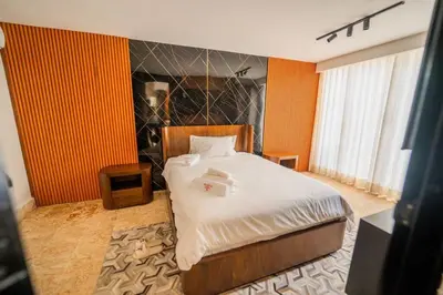 a bedroom with a large bed with orange walls at Villa Hermosa en Metro Country Club Juan Dolio in Juan Dolio