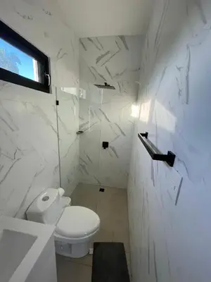 a white bathroom with a toilet and a window at LEVEL suites #8 in Sosúa