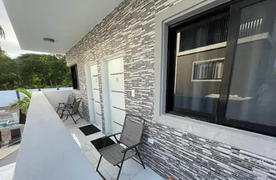 a patio with chairs and a large window at LEVEL suites #8 in Sosúa