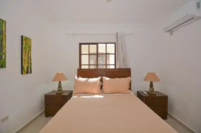 a bedroom with a large bed with two lamps at Rosa Hermosa Penthouse | Vista Piscina • Bávaro in Punta Cana