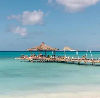 a group of people sitting on a dock in the ocean at Bayahibe Cadaques Caribe Apartment in Bayahibe