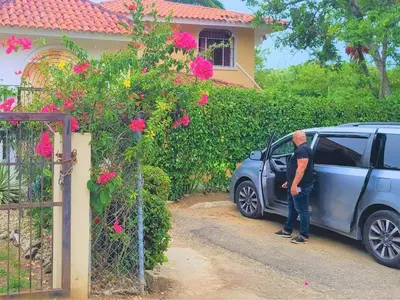 a man standing next to a car in front of a house at Linkzup Playa Laguna Villa in Sosúa