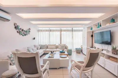 a living room with a couch and a tv at Unique gem penthouse in playa bonita in Las Terrenas
