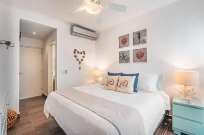 a bedroom with a large white bed with two lamps at Unique gem penthouse in playa bonita in Las Terrenas