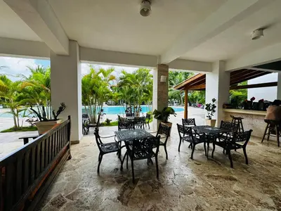 a patio with tables and chairs and a view of the ocean at Vista Bayahibe Paradise in Bayahibe