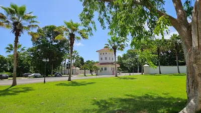 a building in a park with palm trees at Hispaniola Beach Retreat in Sosúa