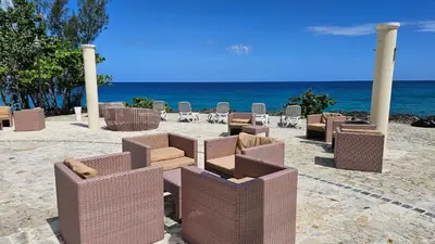 a group of chairs and tables on the beach at Hispaniola Beach Retreat in Sosúa