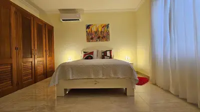 a bedroom with a bed and a painting on the wall at Hispaniola Beach Retreat in Sosúa