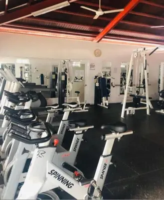 a gym with a bunch of machines in a room at Harmony II , 5 Min to Airport, Pool View Balcony in Santiago de los Caballeros