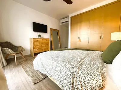 a bedroom with a bed and a tv on the wall at Exclusivo penthouse con piscina en Playa Bávaro in Punta Cana
